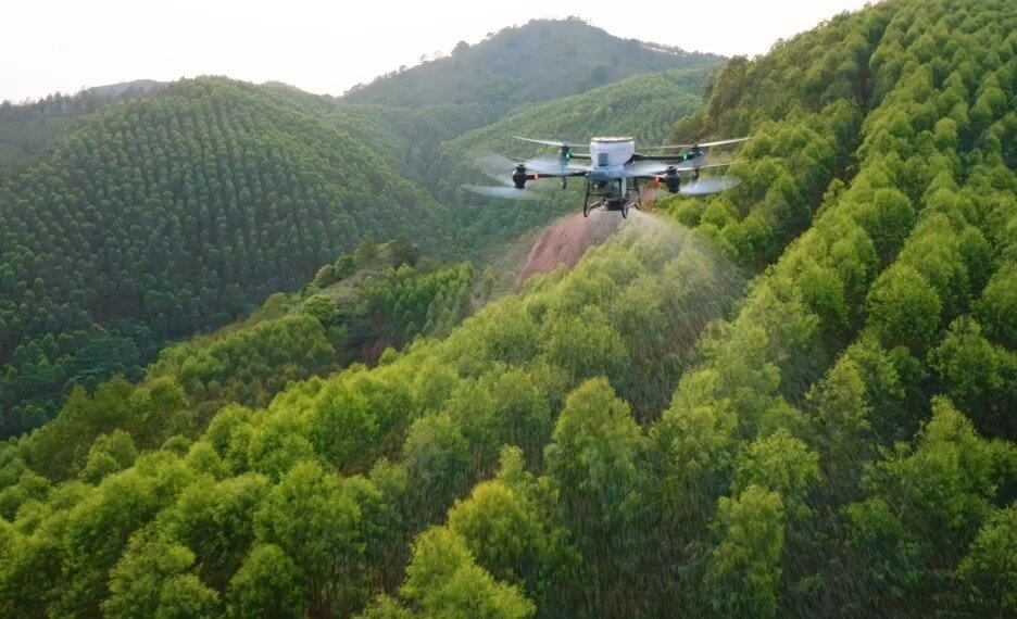 DJI AGRAS T50 em voo de pulverização sobre um pomar
